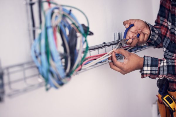 Electrician, technician and hands of man with cable maintenance, inspection and home repair. Constr.