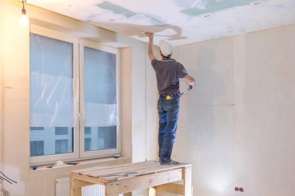 Worker make repairs in new apartment. Man plaster walls and ceilings. High quality photo